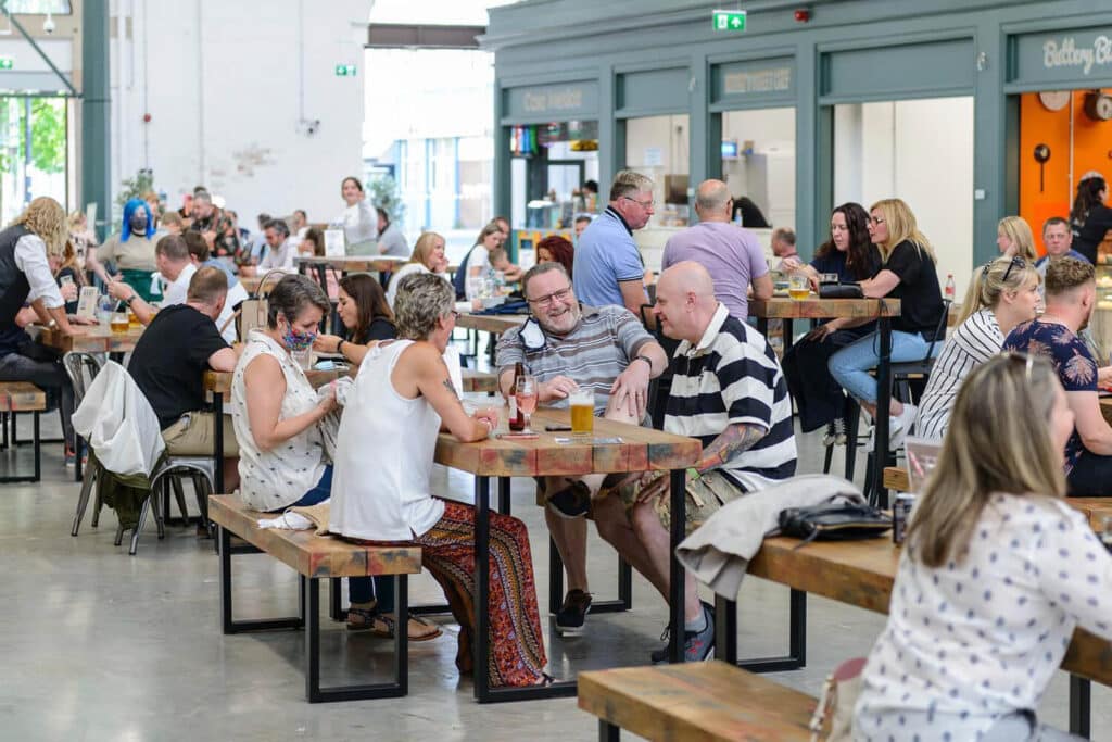 People enjoying drinks outside food stalls